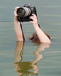 Fotograf steht bis über dem Kopf im Wasser und hält die Kamera hoch
